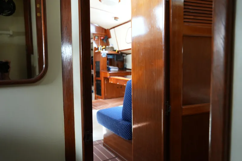 Peggy Lee Yacht Photos Pics Interior view of 1984 Irwin 52 Cutter Ketch, featuring wooden cabinetry and blue seating.