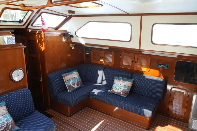 Peggy Lee Yacht Photos Pics Interior of 1984 Irwin 52 Cutter Ketch with cozy seating and nautical decor.