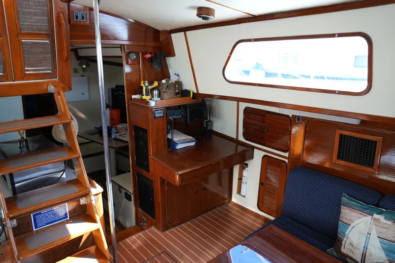 Peggy Lee Yacht Photos Pics Interior of 1984 Irwin 52 Cutter Ketch, featuring wooden cabinetry and seating area.