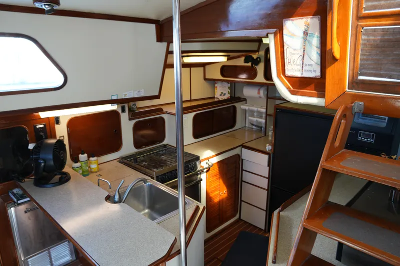 Peggy Lee Yacht Photos Pics Interior of 1984 Irwin 52 Cutter Ketch, featuring a compact kitchen with wooden cabinetry.