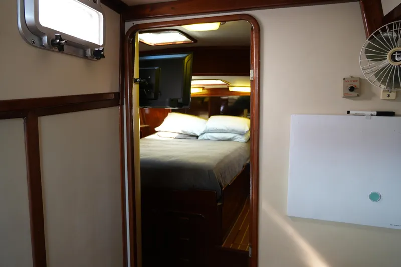 Peggy Lee Yacht Photos Pics Interior cabin of 1984 Irwin 52 Cutter Ketch, featuring a cozy bed and wooden accents.