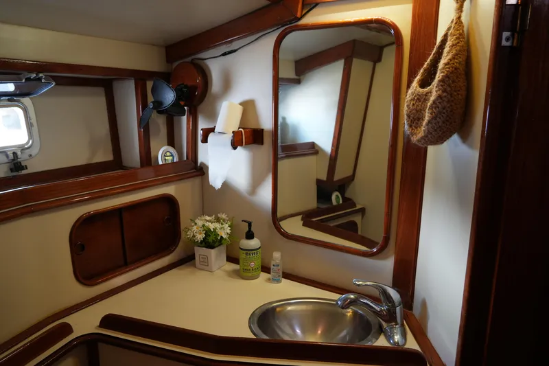 Peggy Lee Yacht Photos Pics 1984 Irwin 52 Cutter Ketch bathroom with sink, mirror, and wooden accents.