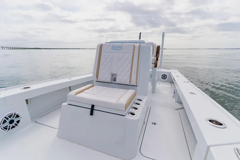  Yacht Photos Pics 2026 Broadwater 25 Bay Cat boat interior with cushioned seating on calm water.