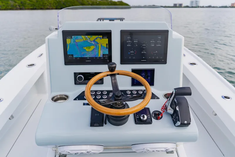  Yacht Photos Pics Control console of 2026 Broadwater 25 Bay Cat boat with dual screens and wooden steering wheel.