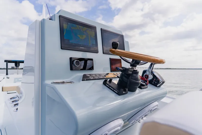  Yacht Photos Pics Control panel of 2026 Broadwater 25 Bay Cat boat with navigation screens and steering wheel.