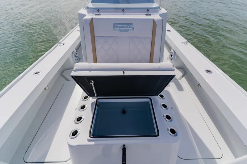  Yacht Photos Pics 2026 Broadwater 25 Bay Cat boat interior with open storage compartment on water.