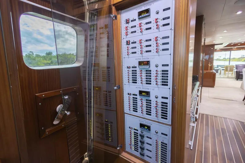 Okie Dokie Yacht Photos Pics Electrical control panel on 2009 Hargrave Enclosed Bridge yacht, featuring wood paneling and modern interior.