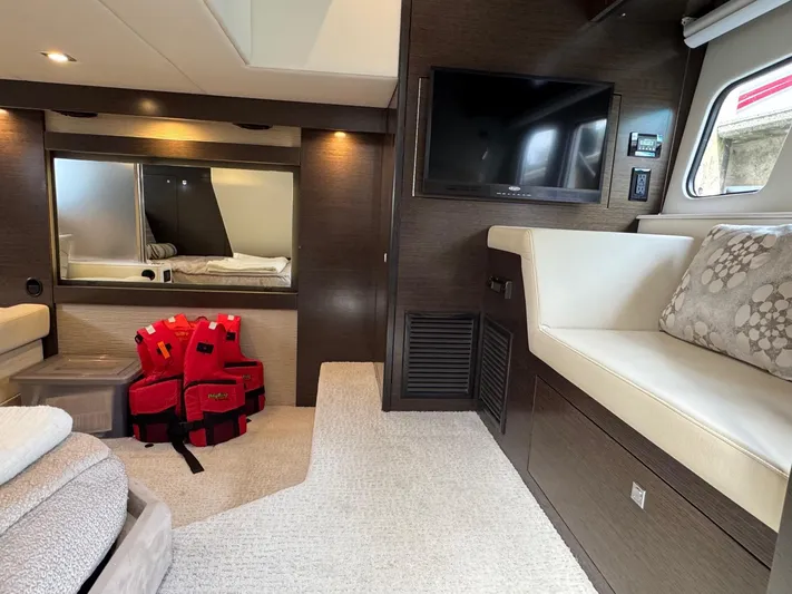  Yacht Photos Pics Luxurious interior of 2017 Cruisers Yachts 45 Cantius with TV, seating, and life jackets.