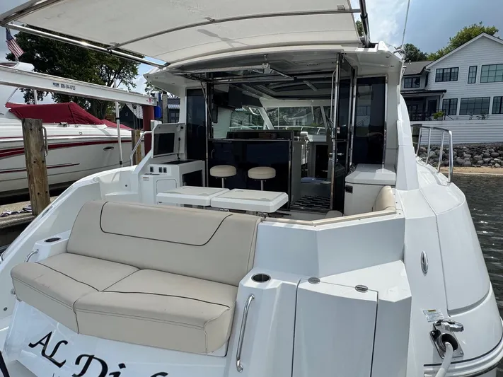  Yacht Photos Pics 2017 Cruisers Yachts 45 Cantius with spacious deck and seating, docked by waterfront homes.