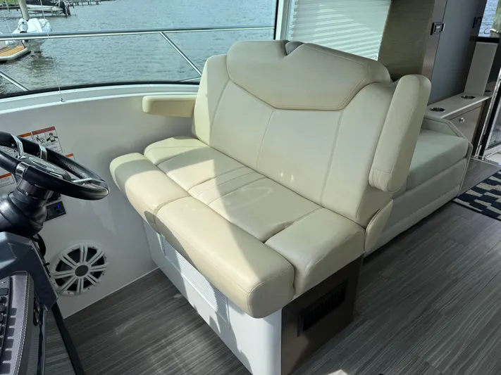  Yacht Photos Pics Helm seating on 2017 Cruisers Yachts 45 Cantius, featuring beige upholstery and modern design.