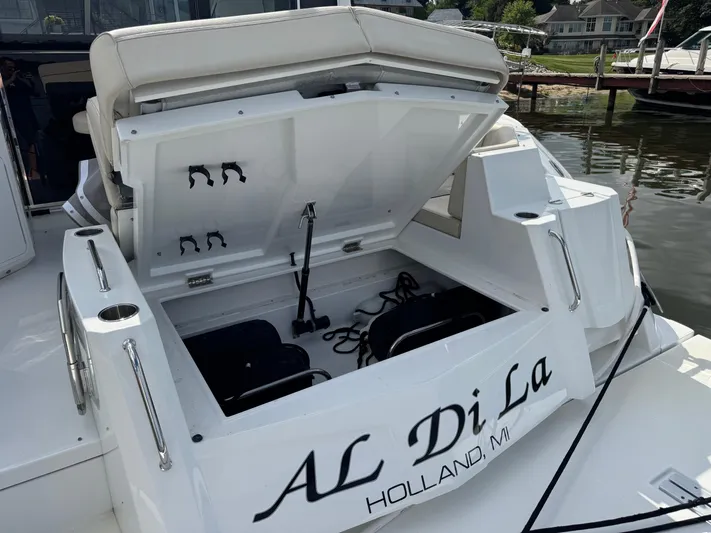  Yacht Photos Pics 2017 Cruisers Yachts 45 Cantius with open storage compartment, docked near waterfront homes.