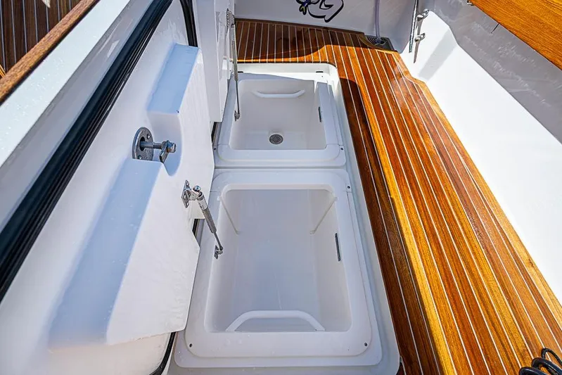 Big Stink Yacht Photos Pics 2026 Viking 54 Convertible yacht with open storage compartments on polished wooden deck.