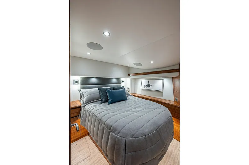 Big Stink Yacht Photos Pics Luxurious bedroom interior of 2026 Viking 54 Convertible yacht with modern design and cozy bedding.
