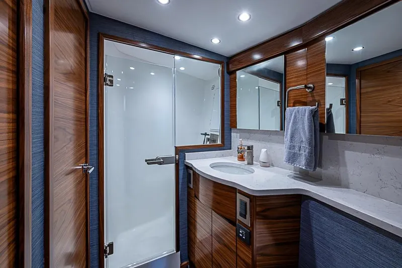 Big Stink Yacht Photos Pics Luxurious bathroom in 2026 Viking 54 Convertible yacht with modern fixtures and wood accents.