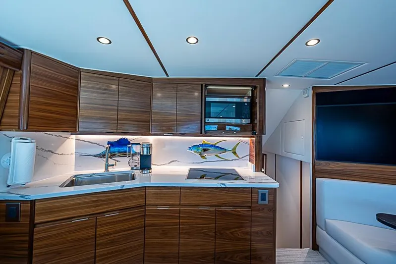 Big Stink Yacht Photos Pics Luxurious kitchen interior of 2026 Viking 54 Convertible yacht with modern wood cabinetry.