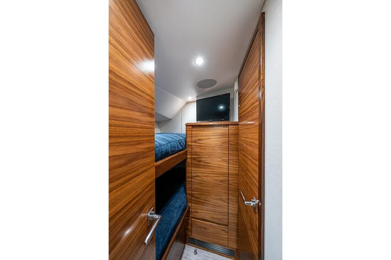 Big Stink Yacht Photos Pics Interior of 2026 Viking 54 Convertible yacht with wooden finish and bunk beds.