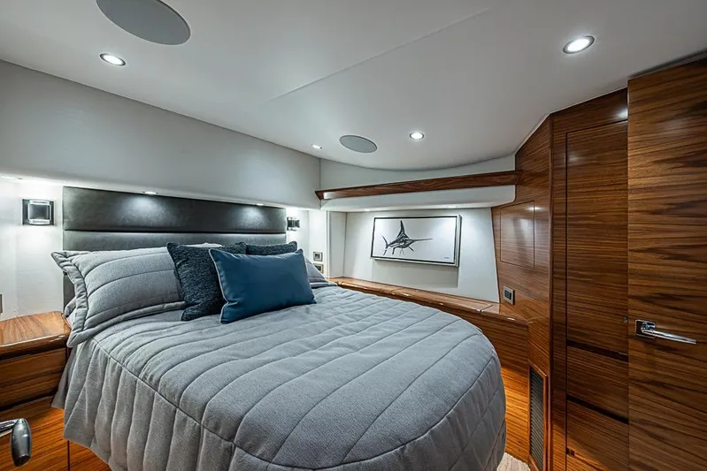 Big Stink Yacht Photos Pics Luxurious bedroom interior of 2026 Viking 54 Convertible yacht with modern design and wood accents.