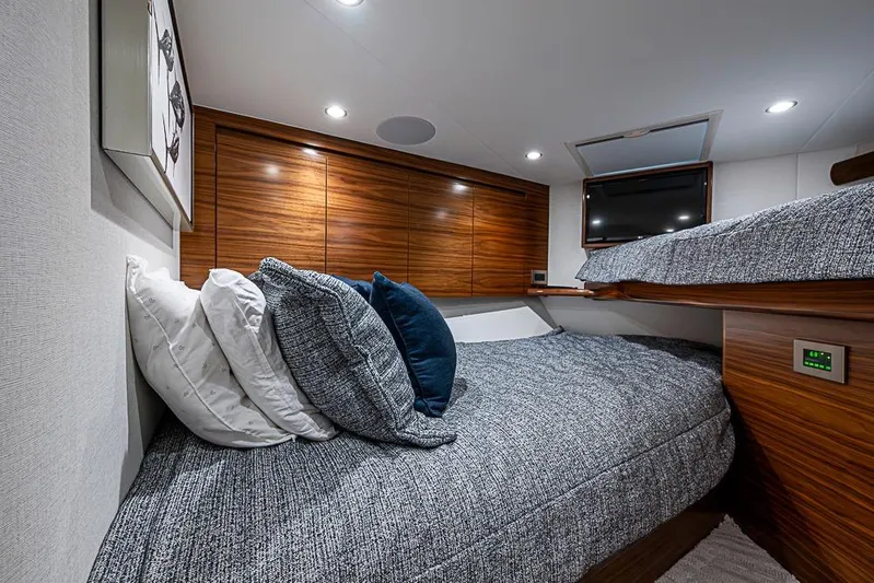 Big Stink Yacht Photos Pics Luxurious cabin interior of 2026 Viking 54 Convertible yacht with cozy bedding and modern design.