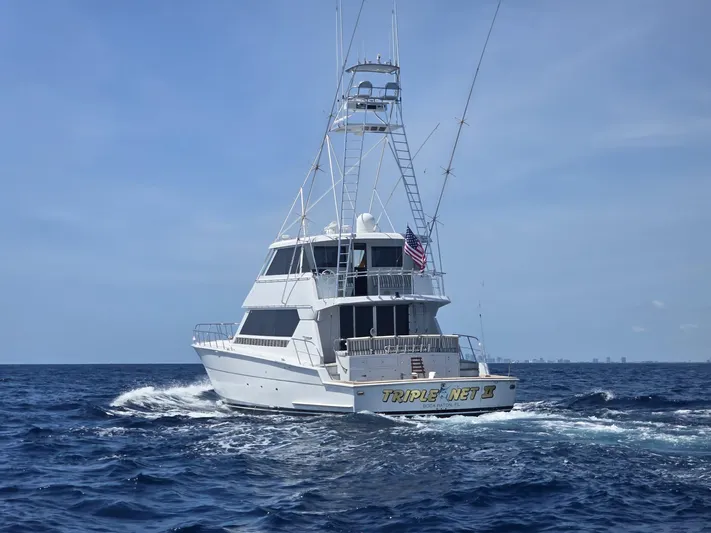 Triple Net II Yacht Photos Pics 1994 Hatteras 82 Convertible yacht cruising on open sea under clear sky.