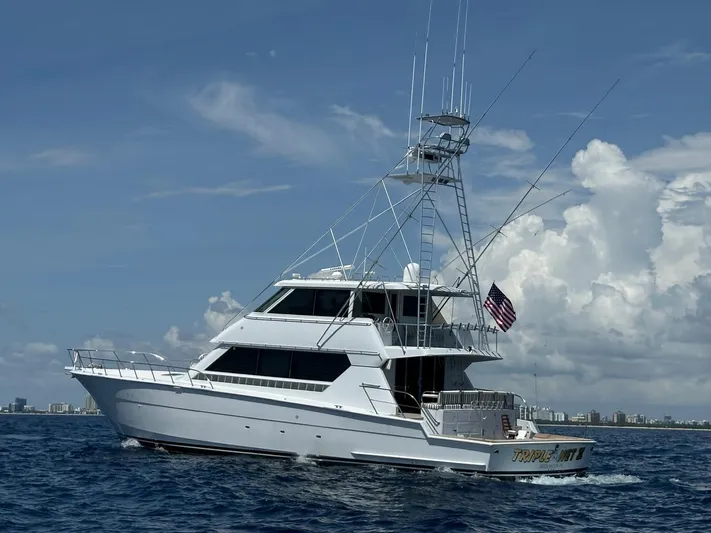 Triple Net II Yacht Photos Pics 1994 Hatteras 82 Convertible yacht cruising on open water under a clear sky.