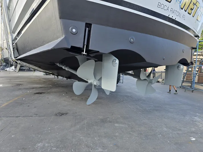 Triple Net II Yacht Photos Pics 1994 Hatteras 82 Convertible yacht with visible propellers, docked for maintenance.