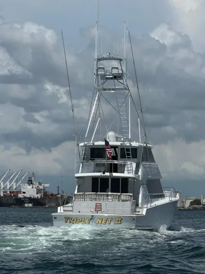 Triple Net II Yacht Photos Pics 1994 Hatteras 82 Convertible yacht cruising in open water under cloudy skies.