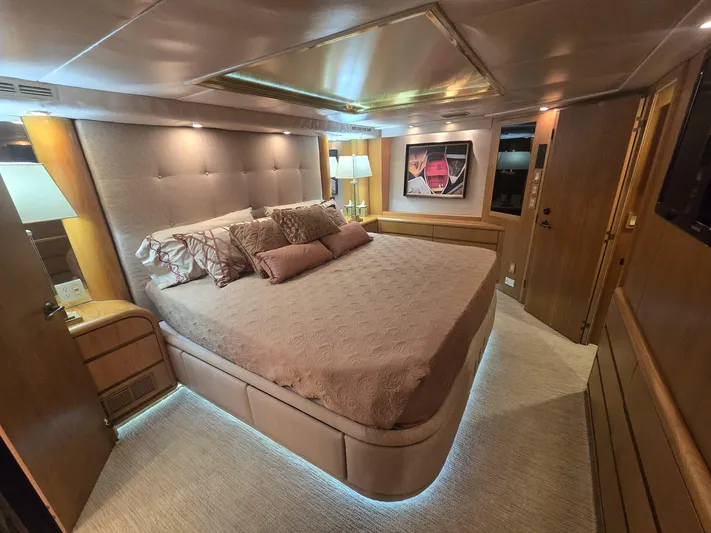 Triple Net II Yacht Photos Pics Luxurious bedroom interior of 1994 Hatteras 82 Convertible yacht with elegant lighting and decor.