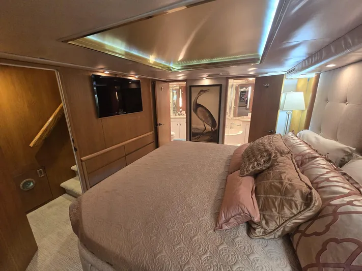 Triple Net II Yacht Photos Pics Luxurious bedroom interior of 1994 Hatteras 82 Convertible yacht with elegant bedding and ambient lighting.
