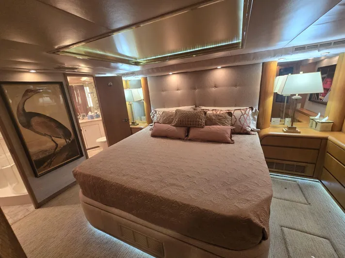 Triple Net II Yacht Photos Pics Luxurious bedroom interior of 1994 Hatteras 82 Convertible yacht with elegant decor and ambient lighting.