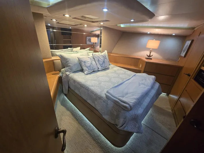 Triple Net II Yacht Photos Pics Luxurious bedroom interior of 1994 Hatteras 82 Convertible yacht with cozy lighting.