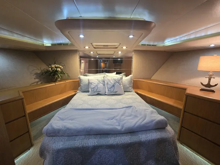 Triple Net II Yacht Photos Pics Luxurious bedroom interior of 1994 Hatteras 82 Convertible yacht with cozy bedding and ambient lighting.