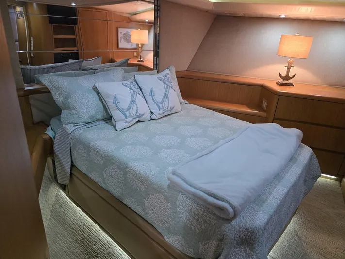 Triple Net II Yacht Photos Pics Luxurious bedroom interior of 1994 Hatteras 82 Convertible yacht with nautical-themed decor.