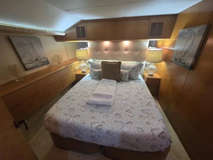 Triple Net II Yacht Photos Pics Luxurious bedroom interior of 1994 Hatteras 82 Convertible yacht with elegant decor and cozy bedding.