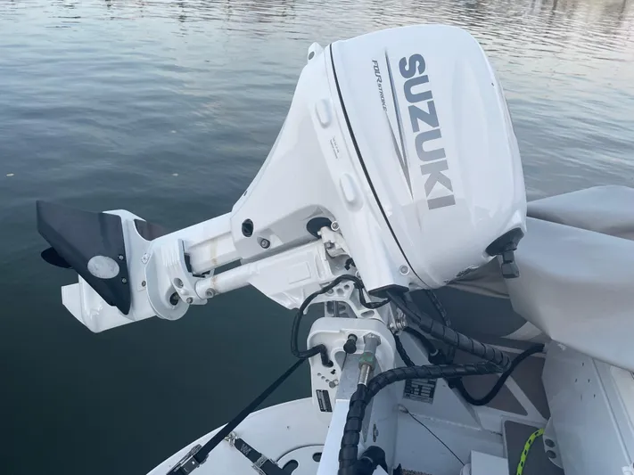 Lisa Ann Yacht Photos Pics Suzuki outboard motor on a 2003 Sea Ray 460 Sundancer, docked on calm water.
