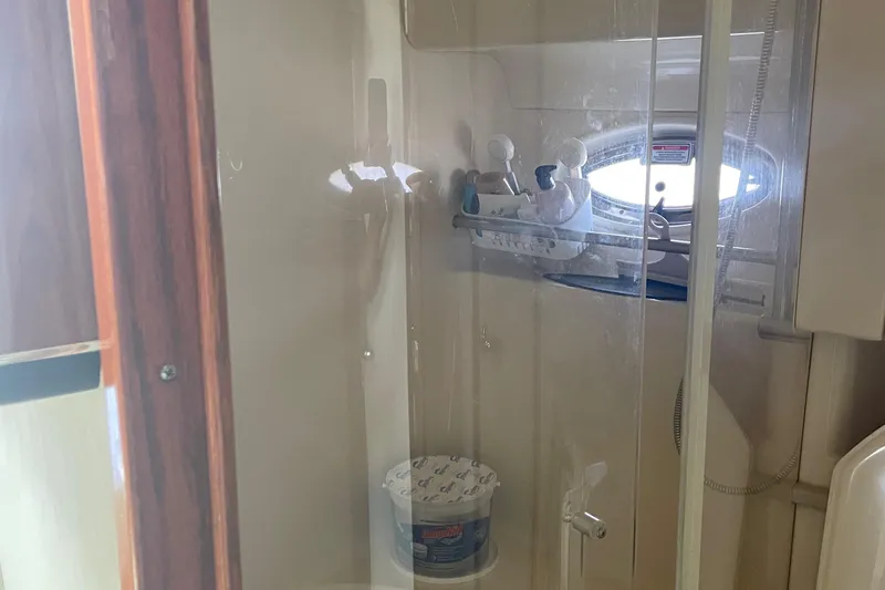 Lisa Ann Yacht Photos Pics Shower area inside 2003 Sea Ray 460 Sundancer yacht, featuring glass door and porthole window.