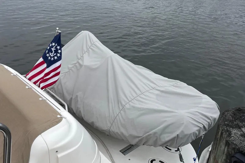 Lisa Ann Yacht Photos Pics 2003 Sea Ray 460 Sundancer with cover and American flag on calm water.