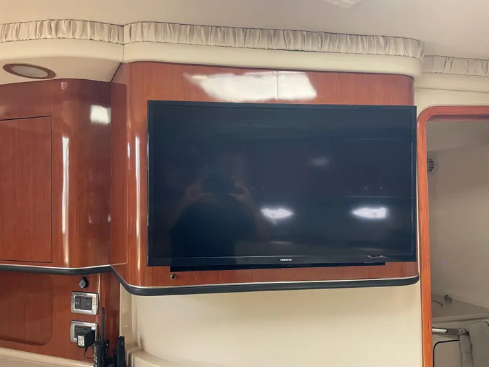 Lisa Ann Yacht Photos Pics Flat-screen TV in 2003 Sea Ray 460 Sundancer yacht interior with wood paneling.