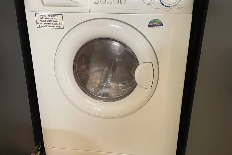 Lisa Ann Yacht Photos Pics Front-loading washing machine with caution label, set in a dark frame.