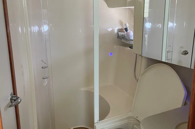 Lisa Ann Yacht Photos Pics Bathroom interior of a 2003 Sea Ray 460 Sundancer yacht, featuring shower and toilet.