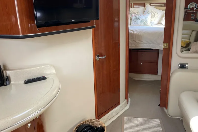 Lisa Ann Yacht Photos Pics Interior of 2003 Sea Ray 460 Sundancer yacht with TV, bed, and wooden cabinetry.