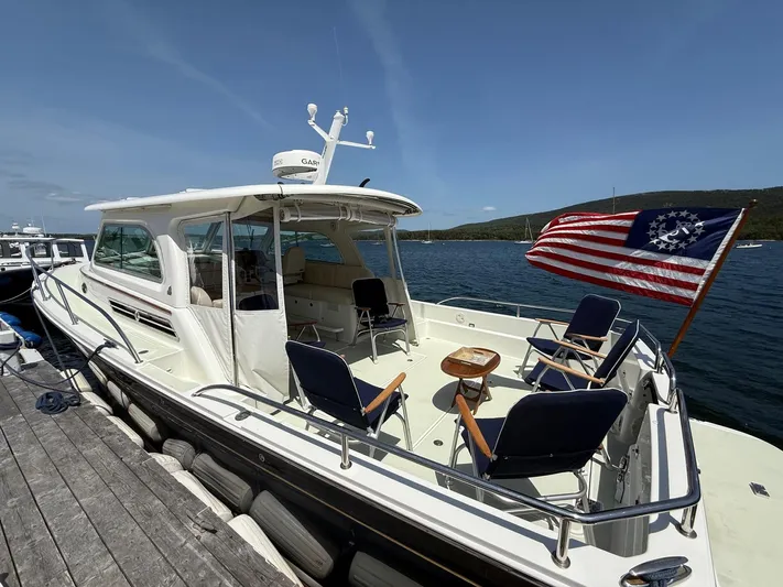 Wahoowa Yacht Photos Pics 2019 Back Cove Downeast boat docked, featuring seating and a historical American flag.