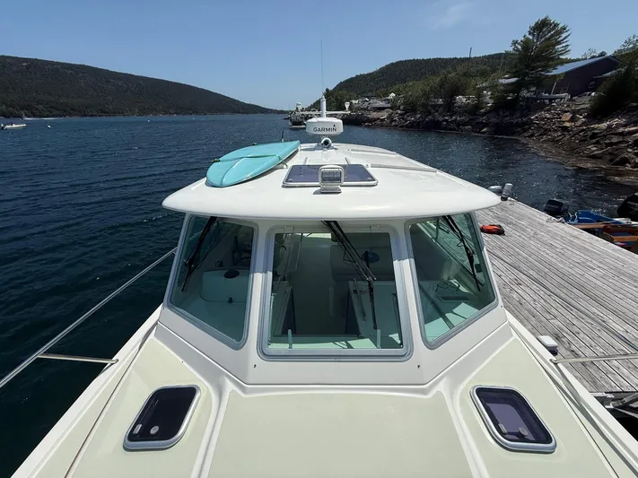 Wahoowa Yacht Photos Pics 2019 Back Cove Downeast boat docked with a paddleboard on deck, scenic waterway view.