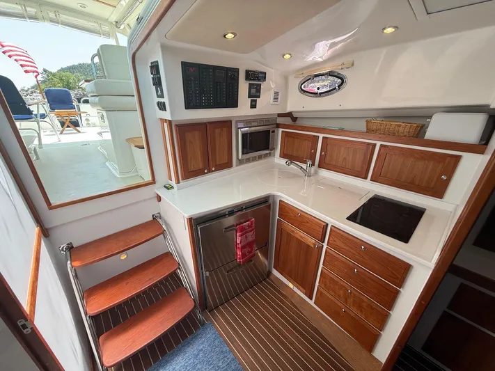 Wahoowa Yacht Photos Pics 2019 Back Cove Downeast yacht interior with modern kitchen and wooden cabinetry.