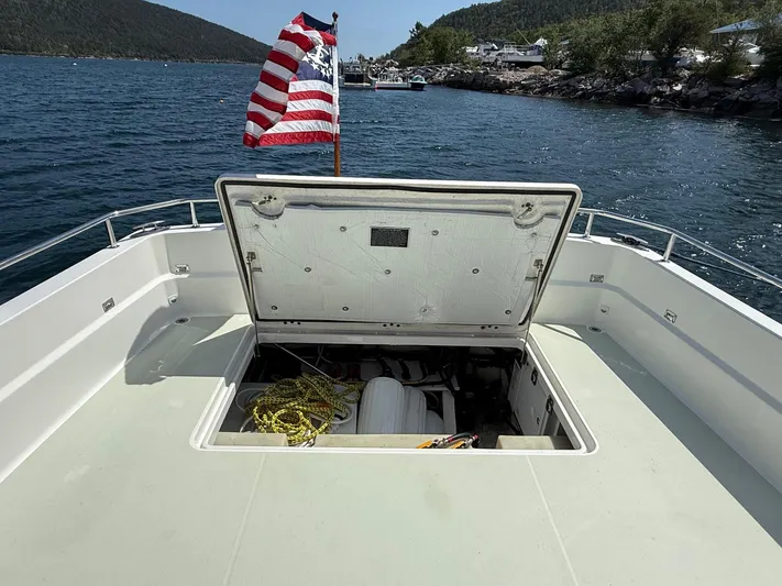 Wahoowa Yacht Photos Pics 2019 Back Cove Downeast boat with open hatch, American flag, and scenic water view.