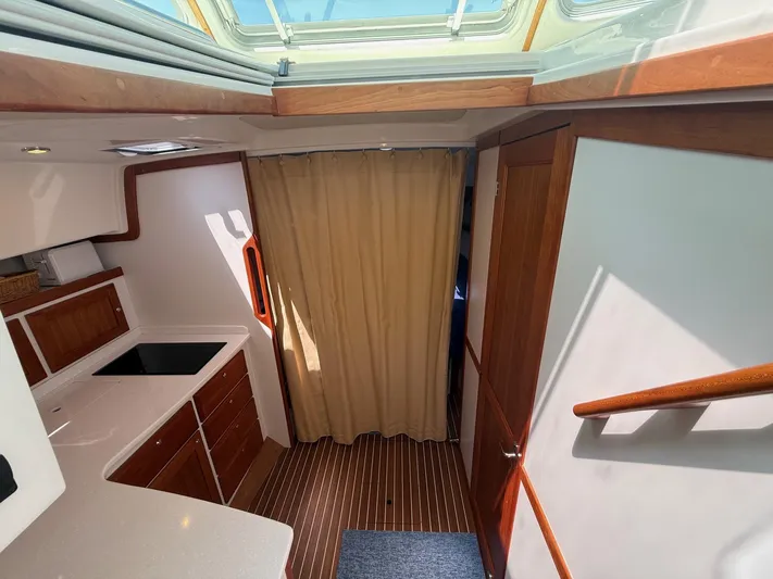 Wahoowa Yacht Photos Pics 2019 Back Cove Downeast interior with wood cabinetry, skylight, and striped flooring.