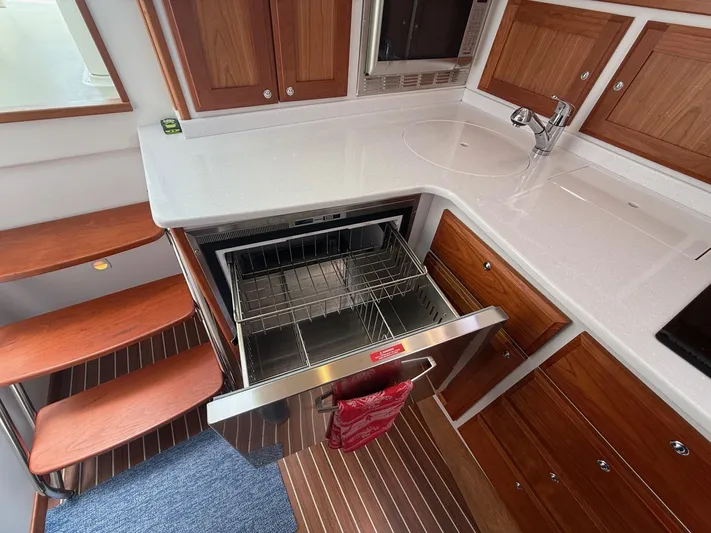 Wahoowa Yacht Photos Pics 2019 Back Cove Downeast yacht kitchen with dishwasher, wooden cabinets, and stairs.