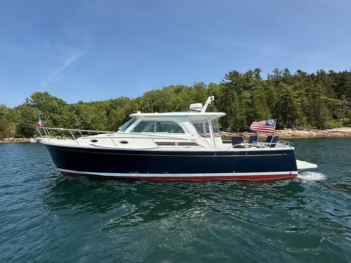 Wahoowa Yacht Photos Pics 2019 Back Cove Downeast boat cruising on a scenic lake with forested shoreline.
