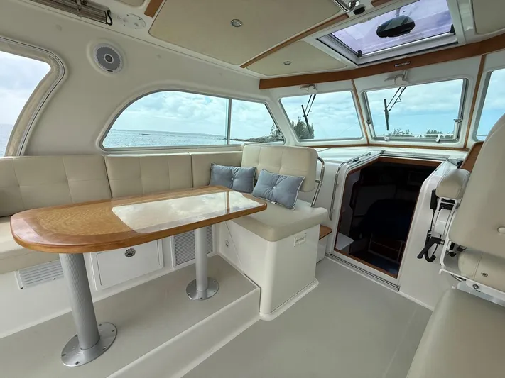 Wahoowa Yacht Photos Pics 2019 Back Cove Downeast boat interior with plush seating, wooden table, and ocean view.
