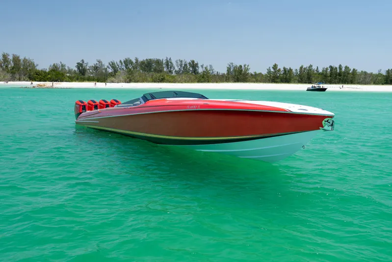 Lady Lisa Yacht Photos Pics 2023 Nor-Tech 55 Flyer boat on turquoise water near a sandy beach.