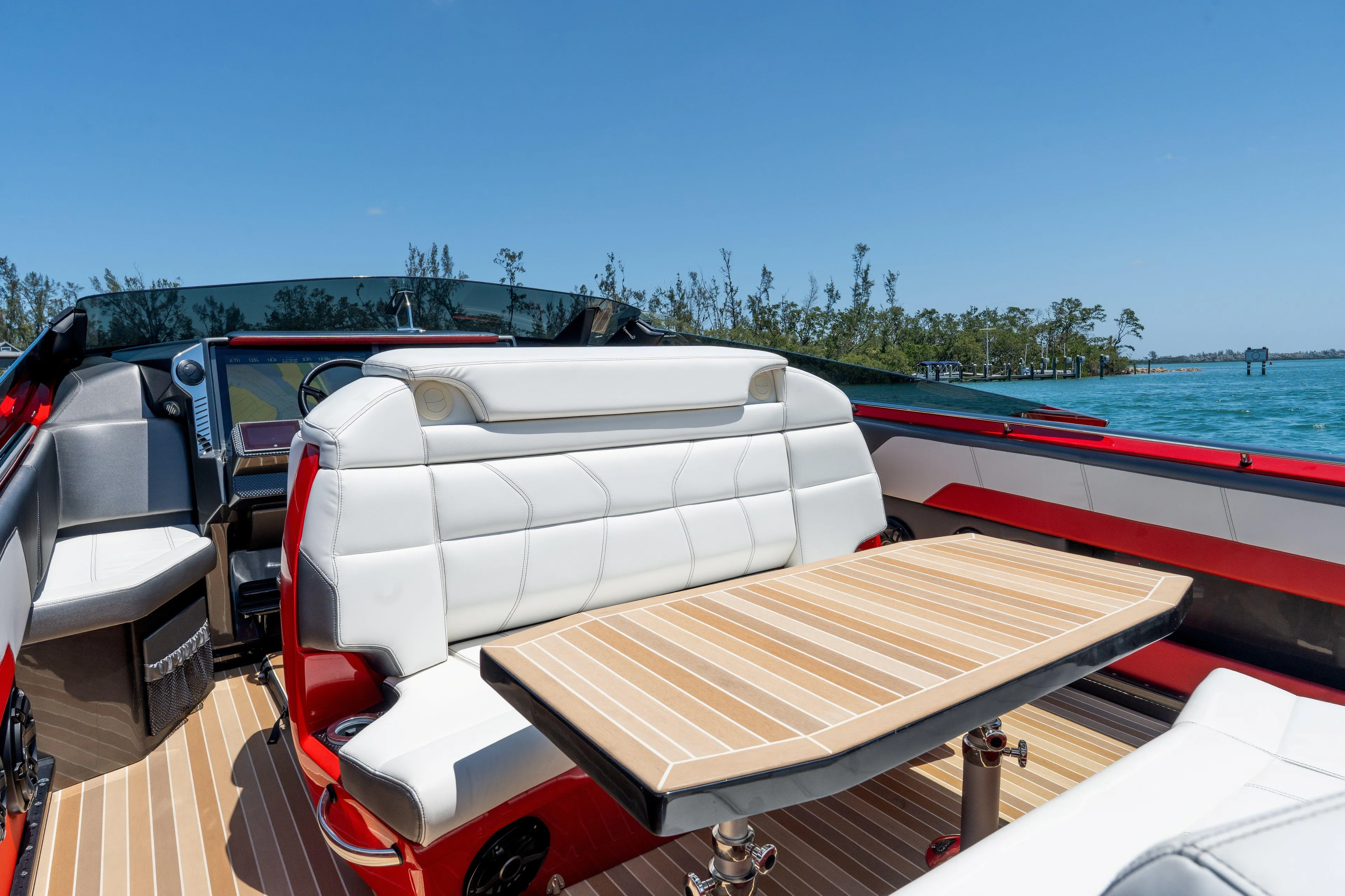 Lady Lisa Yacht Photos Pics 2023 Nor-Tech 55 Flyer boat interior with white seating and wooden table on a sunny day.